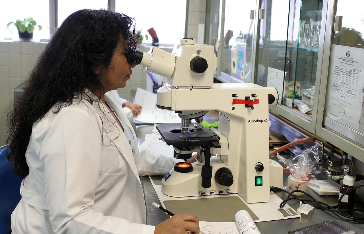 Pharma scientist performing microscope quality checks